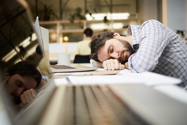 Homme fatigué endormi sur son bureau au travail